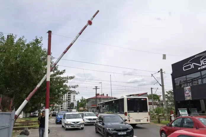 Femeia care ridică manual o barieră feroviară de 36 de ani. O fotografie ce reflectă condiția infrastructurii din România.